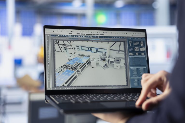 Solar panels manufacturing plant worker developing new photovoltaic materials and technologies using laptop. Close up of photovoltaics factory specialist conducting experiments on notebook